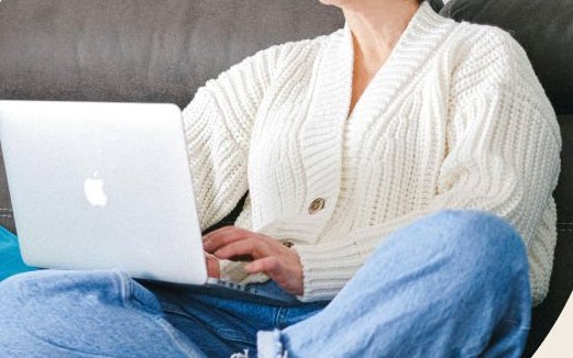 A business owner working on a laptop at home